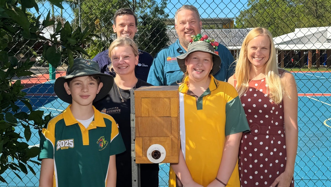 Watching the hive installation at St Matthew’s Catholic Primary School are students James Edward and Pippa Gondon with, from left, Natasha Roebig (Bee All Natural), Alexander Vanek (Logan City Council) Jason Roebig (Bee All Natural) and Cr Miriam Stemp.