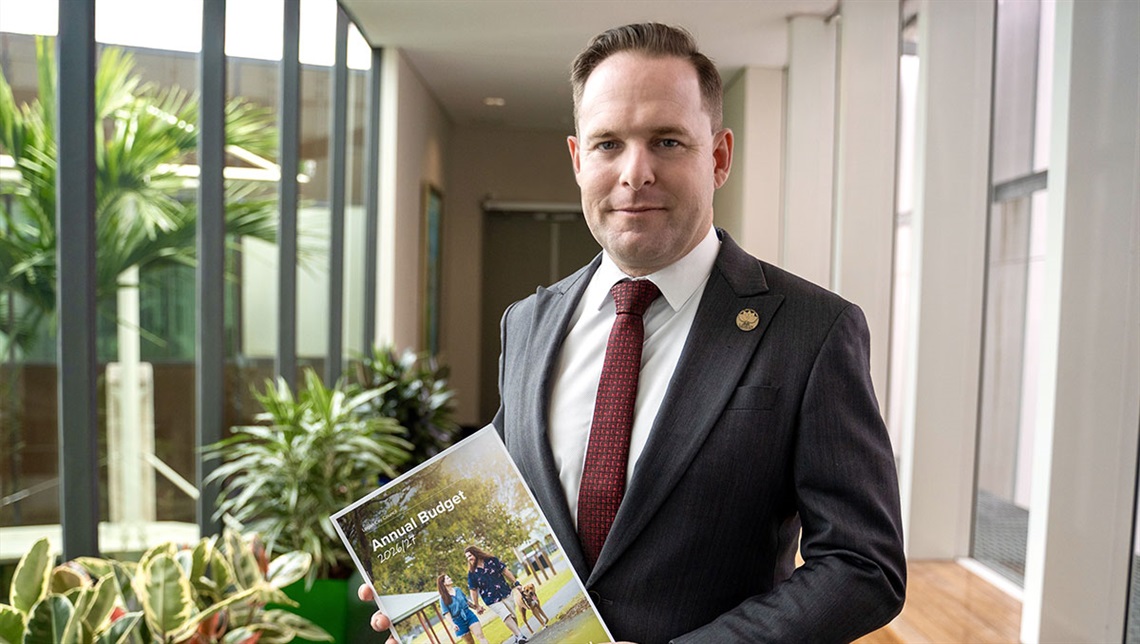 Logan Mayor Jon Raven holding 2026 Budget document