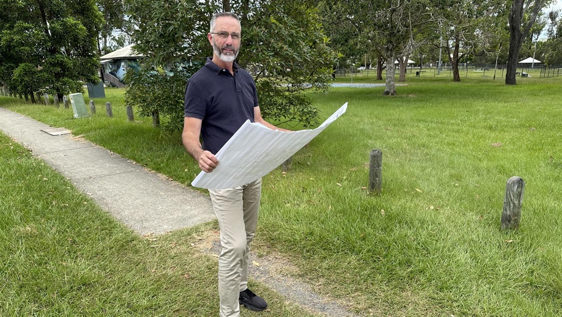 Councuillor Jackson holding a set of plans for footpath extension at Marsden
