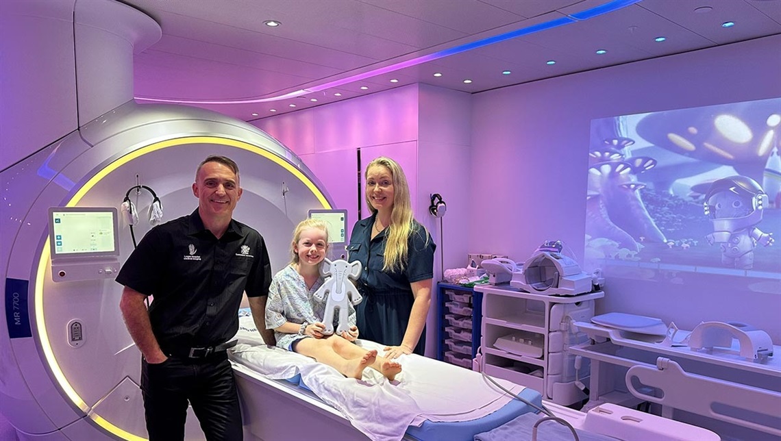 Patient Eleni Griffith holds a kitten scanner, with her mum Rebecca and Logan Hospital Senior MRI Radiographer Des Hardman