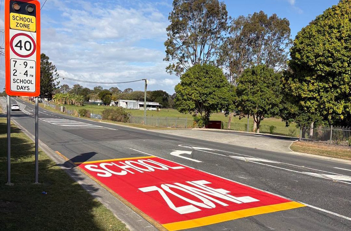 School zone sign next to large School Zone paintwork on the road