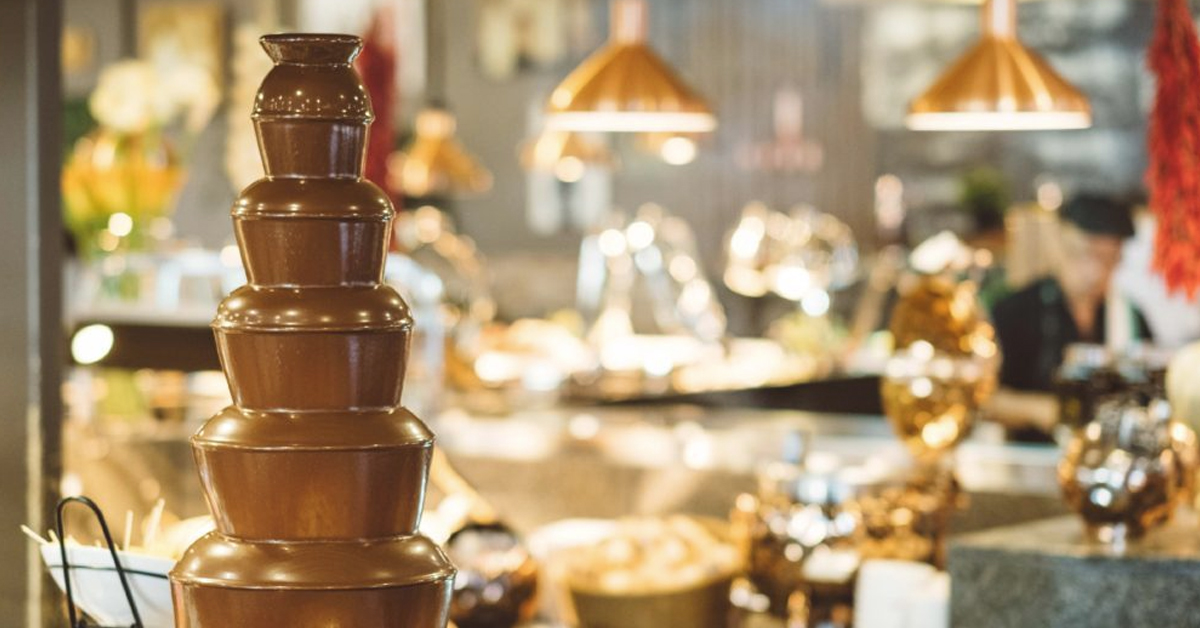 A chocolate fountain on a table in a restaruant