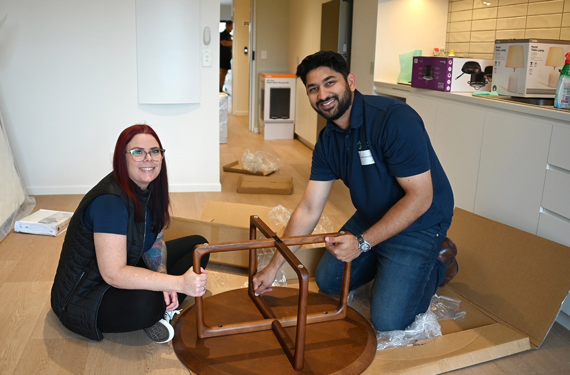 Man and woman on their knees building a coffee table together in a new unit