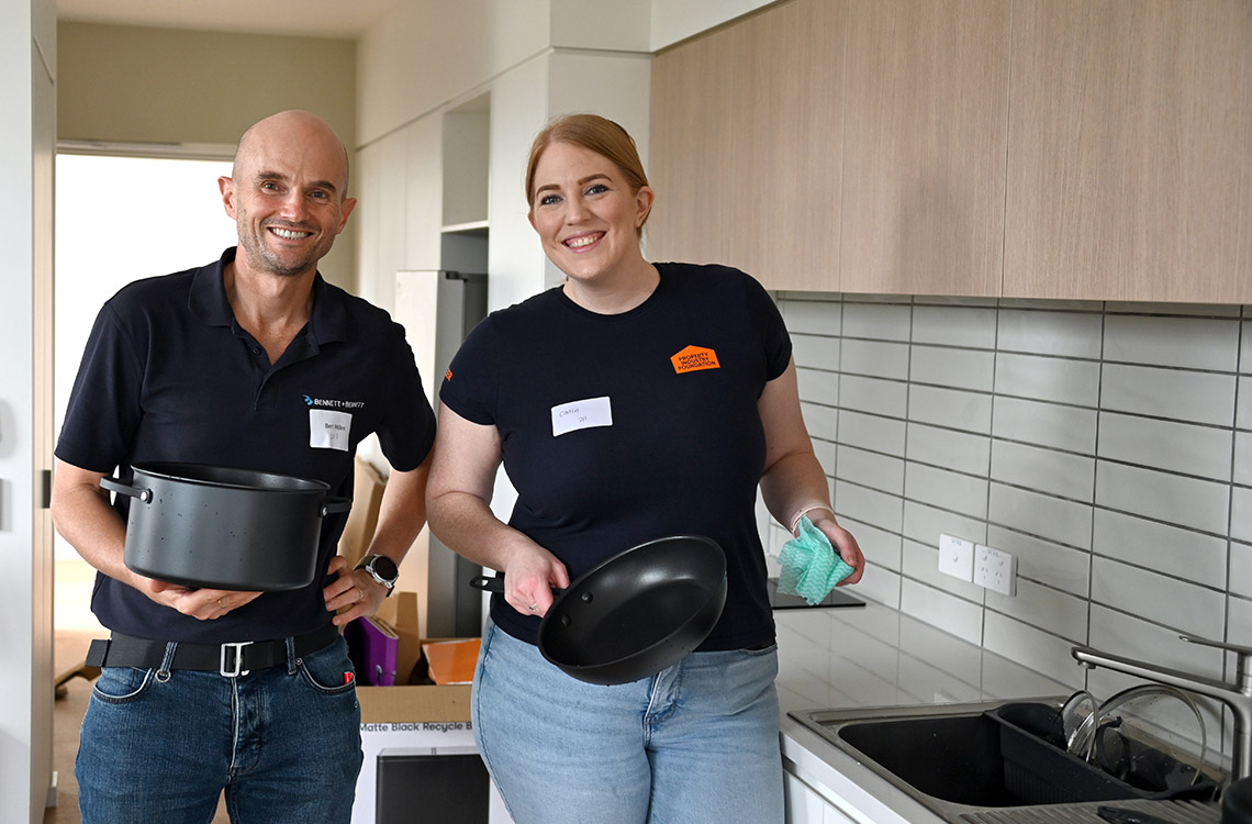 Man and woman holding pots and pans in the kitchen of brand new apartment