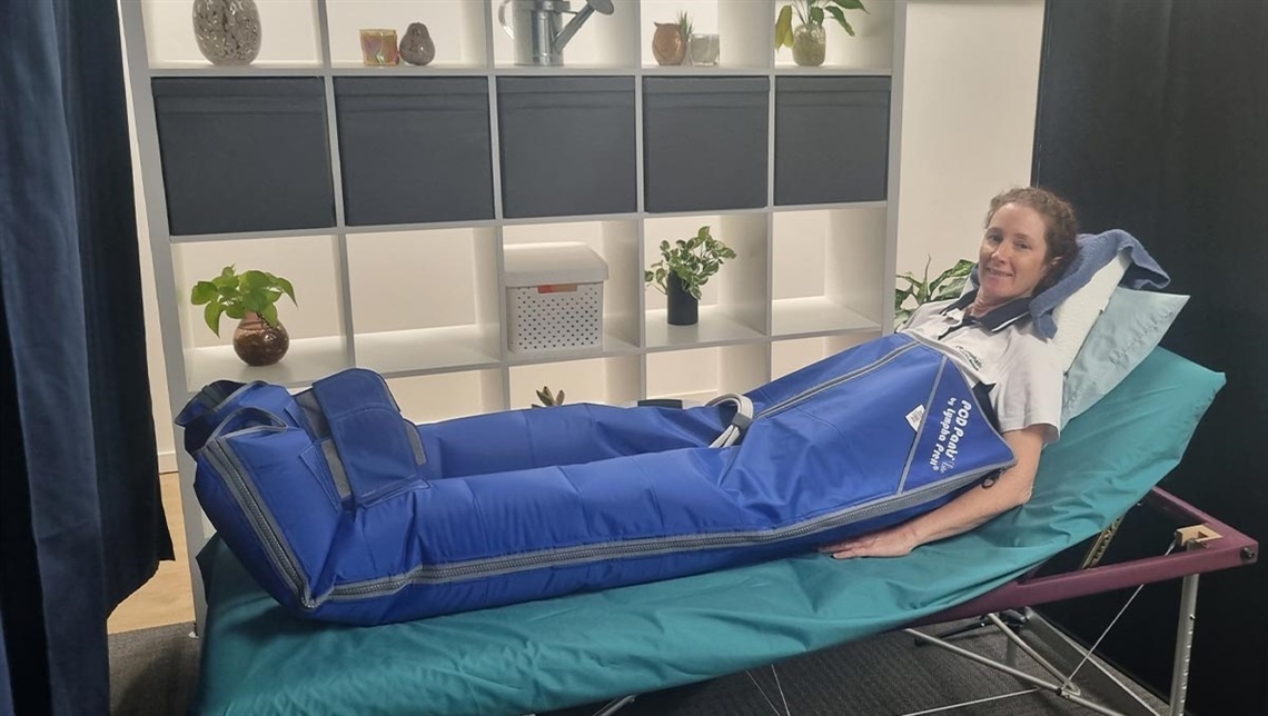 A person sitting in a bed with a lymphatic blanket