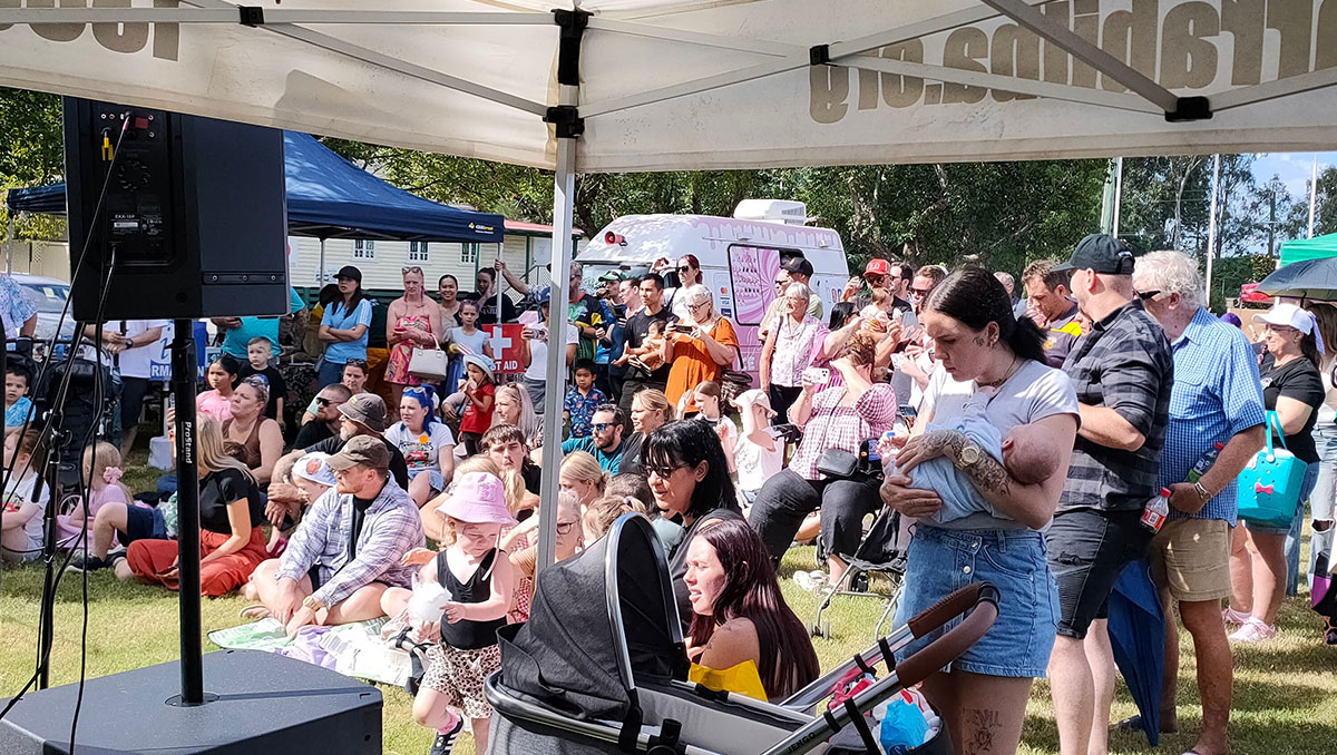 A group of people sitting and standing at a neighbour day event