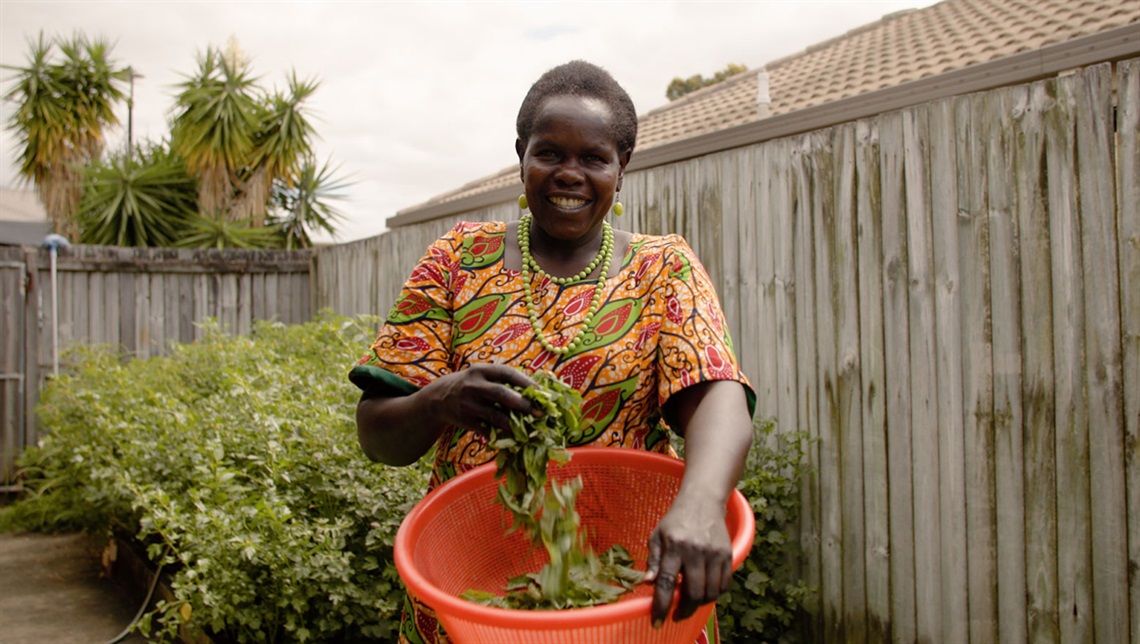 Cecilia Ossa holding a bucket with vegetables